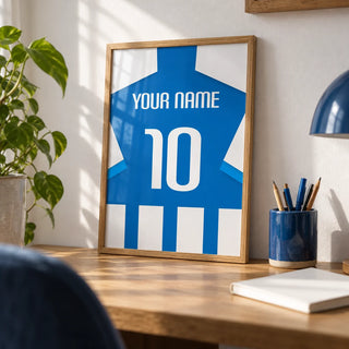 Football Shirt Poster in Blue and White Stripes with Striped Sleeves, a small A4 framed print leaning on an oak desk