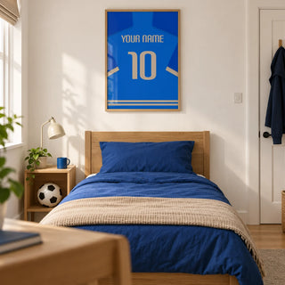 Football Shirt Poster in Blue with Beige Number, framed on the wall of a modern football-loving teenager's single bedroom (13-17) in a UK family home with a warm white wall and oak floor