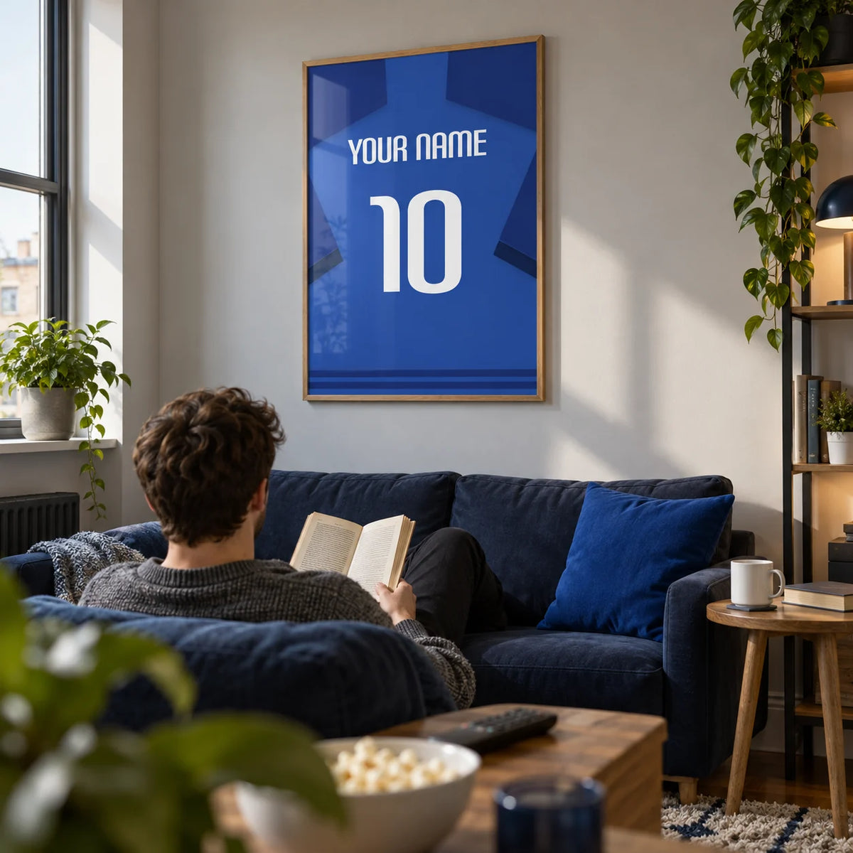 Football Shirt Poster in Blue with Dark Blue Sleeves and White Number, framed on the wall of a modern football-watching snug in a young adult's UK first flat (22-28) with a soft grey wall in a living room