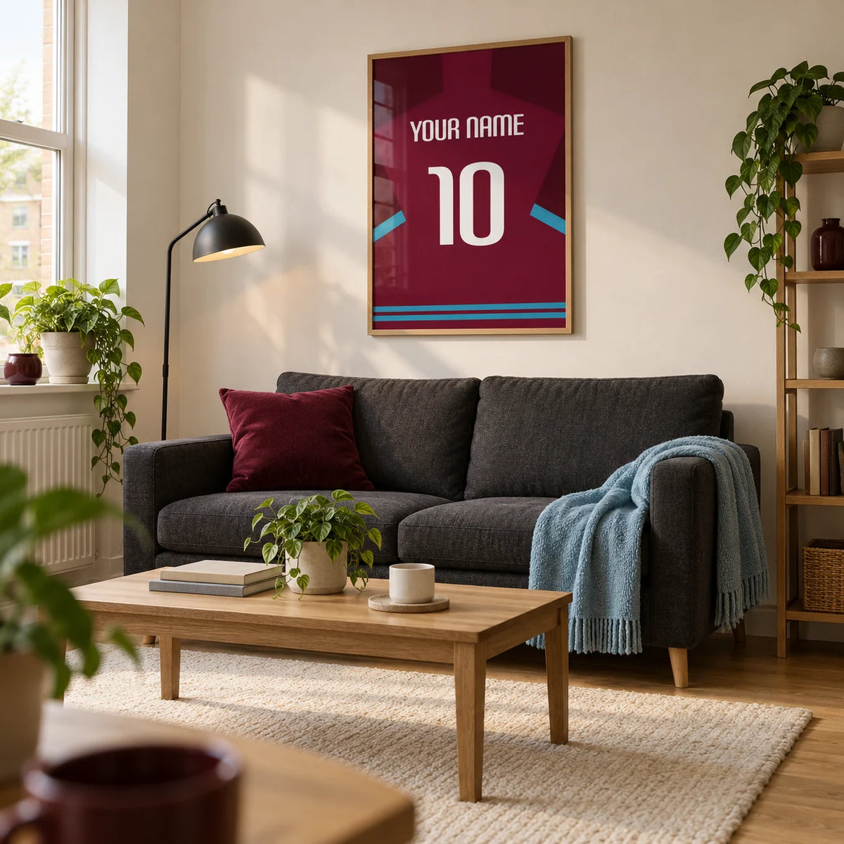 Football Shirt Poster in Claret with Light Blue Sleeve Trim, framed on the wall of a compact modern living room in a UK first flat (22-28) with warm white walls and an oak floor