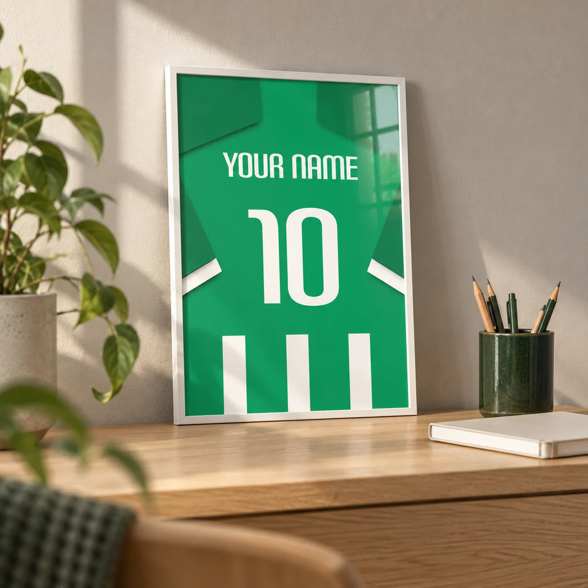 Football Shirt Poster in Green and White Stripes, a small A4 framed print leaning on a pale oak desk