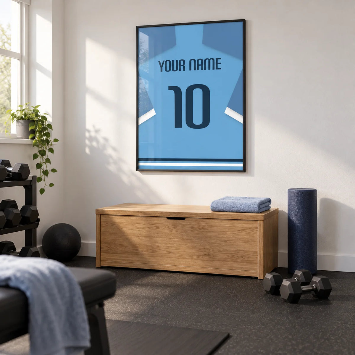 Football Shirt Poster in Light Blue with Dark Blue Number, framed on the wall of a small converted spare-room gym in a UK home with a white wall and plain charcoal rubber flooring