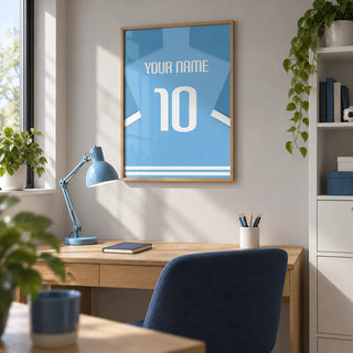 Football Shirt Poster in Light Blue with White Number, framed on the wall of a tidy home study for a young adult football fan with a soft grey wall and a white storage cabinet