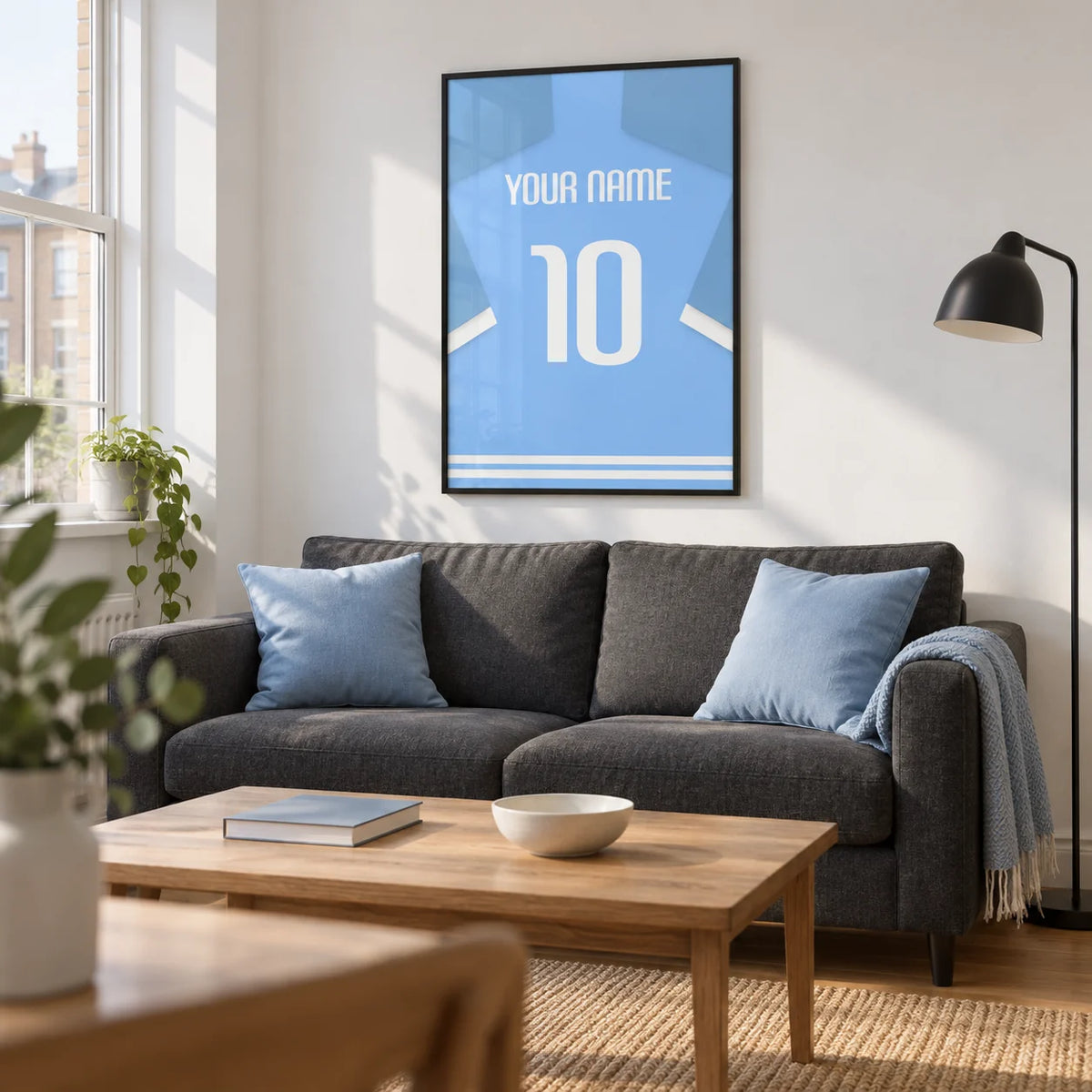 Football Shirt Poster in Light Blue with White Sleeve Stripes, framed on the wall of a bright modern living room in a football fan's first UK flat (22-28)