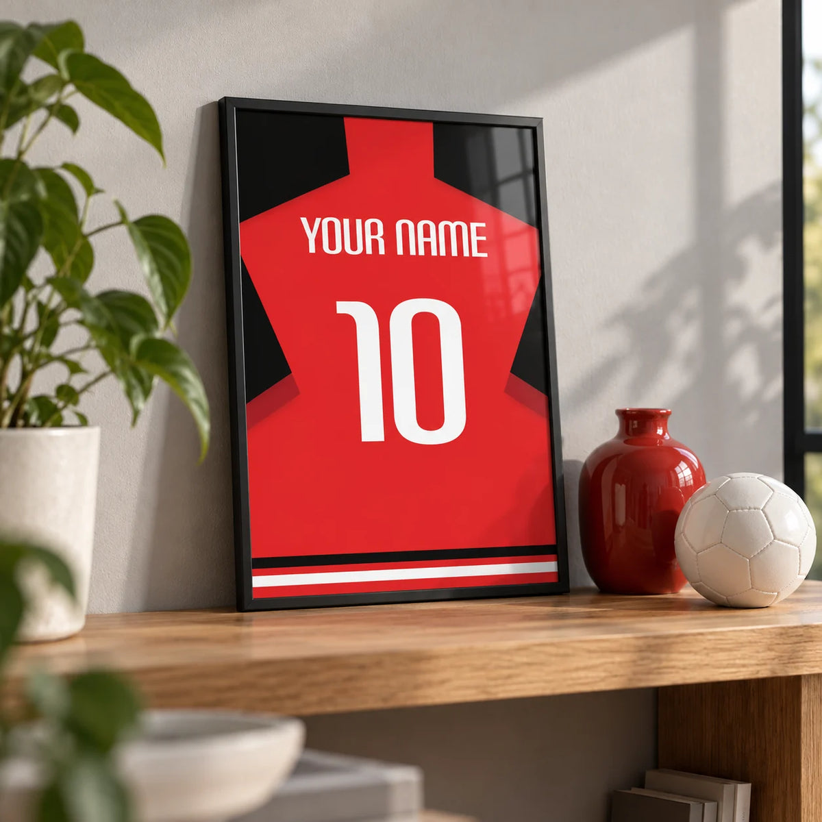 Football Shirt Poster in Plain Red with White Number, a small A4 framed print leaning on an oak shelf in a living room