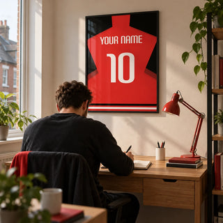 Football Shirt Poster in Plain Red with White Number, framed on the wall of a tidy home study for a young adult football fan (22-35) in a UK terrace with a warm white wall