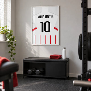 Football Shirt Poster in Red and White Stripes with White Sleeves, framed on the wall of a small home gym in a UK terraced house with a light grey wall and plain dark rubber flooring
