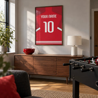 Football Shirt Poster in Red with Bold White 10, framed on the wall of a modern games room in a UK family home with a pale grey wall and oak floor in a living room