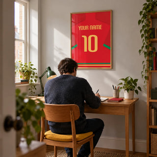 Football Shirt Poster in Red with Green Trim and Yellow Number, framed on the wall of a compact home study in a modern UK terrace with a pale grey wall