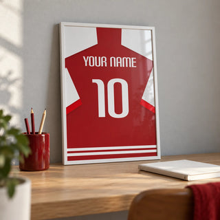 Football Shirt Poster in Red with White Sleeves, a small A4 framed print leaning on a pale oak desk