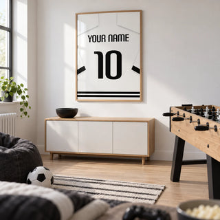 Football Shirt Poster in White with Black Banded Sleeves and Black Number, framed on the wall of a compact modern games room in a young football fan's UK home