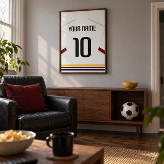 Football Shirt Poster in White with Black Red and Gold Hem Stripes, framed on the wall of a football watching snug in a UK terraced house in a living room