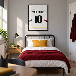 Football Shirt Poster in White with Black Red and Gold Hem Stripes, framed on the wall of a modern football fan's single bedroom in a UK family home