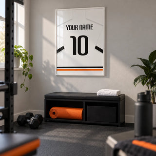 Football Shirt Poster in White with Black Sleeve Bands, framed on the wall of a small home gym in a converted UK spare room with a light grey wall and plain dark rubber flooring