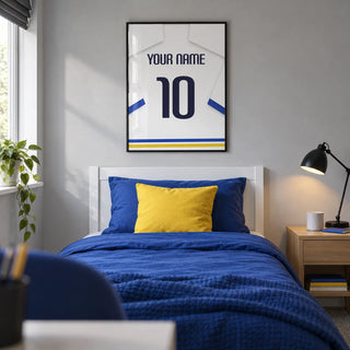 Football Shirt Poster in White with Blue Sleeves and Black Number, framed on the wall of a modern football-loving teenager's single bedroom (13-17) in a UK family home with a pale grey wall