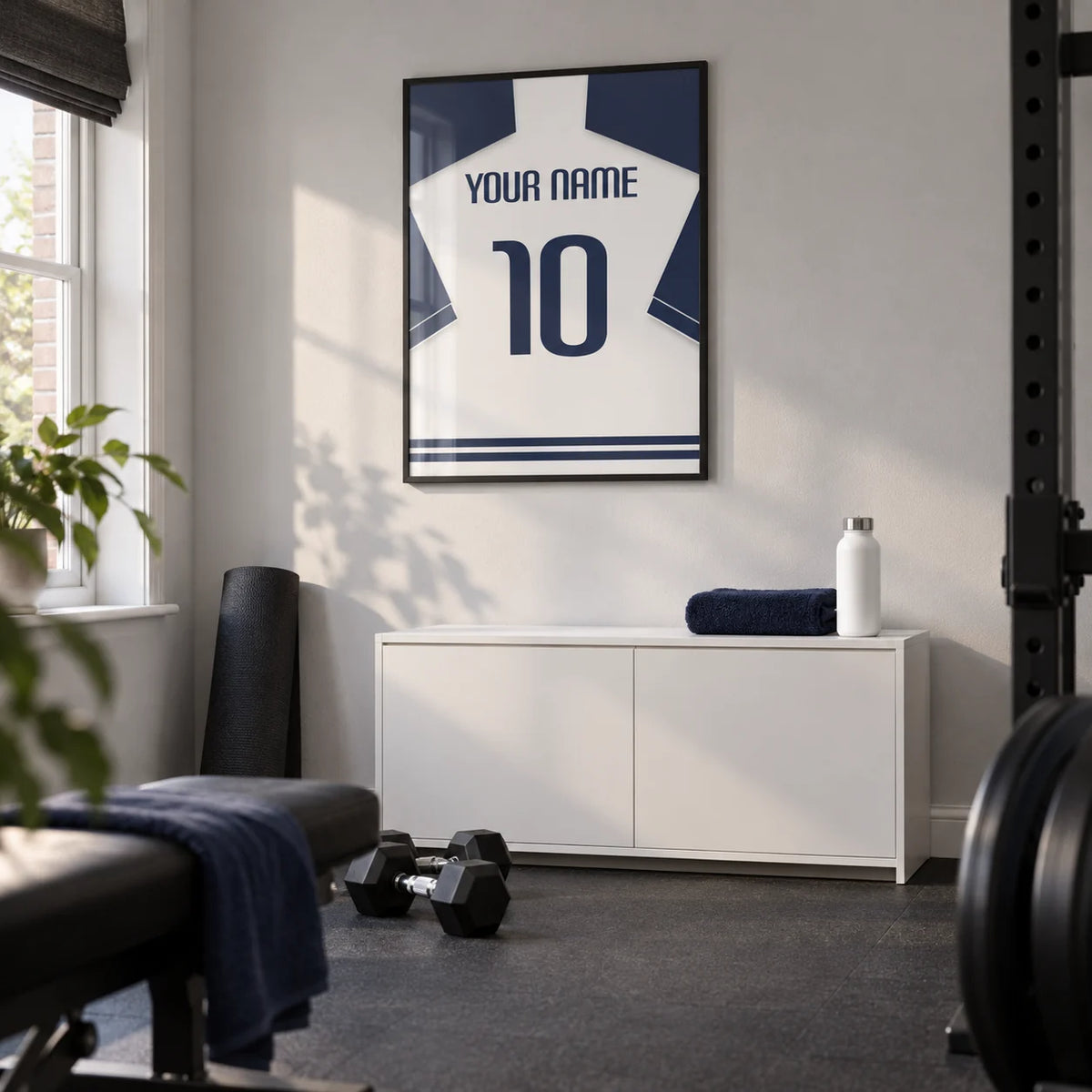 Football Shirt Poster in White with Navy Sleeves and Navy Number, framed on the wall of a modest home gym in a converted UK spare room with a pale grey wall and plain charcoal rubber flooring