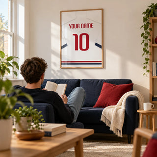 Football Shirt Poster in White with Navy Sleeves and Red Number, framed on the wall of a bright living room in a football fan's first flat (22-28) with a warm white wall and pale oak floor