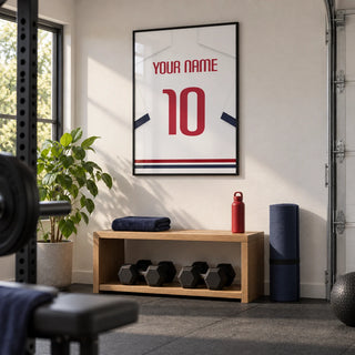 Football Shirt Poster in White with Navy Sleeves and Red Number, framed on the wall of a neat converted garage home gym with a white painted wall and charcoal rubber flooring