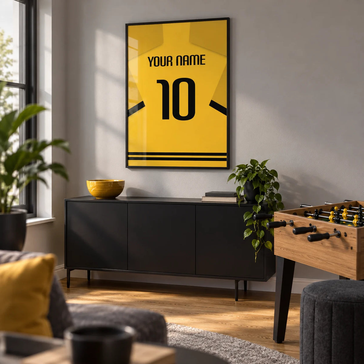 Football Shirt Poster in Yellow with Black Sleeve Stripes, framed on the wall of a modern football-themed games room in a UK home with a pale grey wall and oak floor in a living room