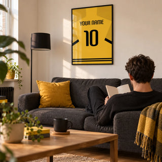 Football Shirt Poster in Yellow with Black Sleeve Stripes, framed on the wall of a young adult football fan’s living room in a UK first flat (22-28)