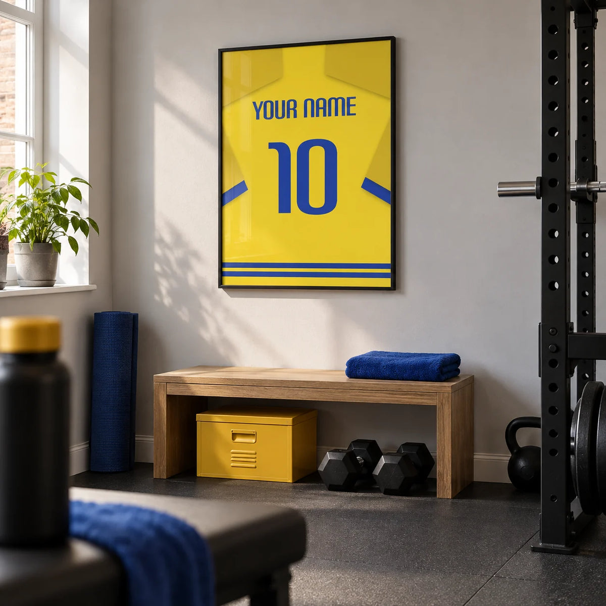 Football Shirt Poster in Yellow with Blue Trim, framed on the wall of a compact home gym in a UK terraced house with a pale grey wall and plain dark rubber floor