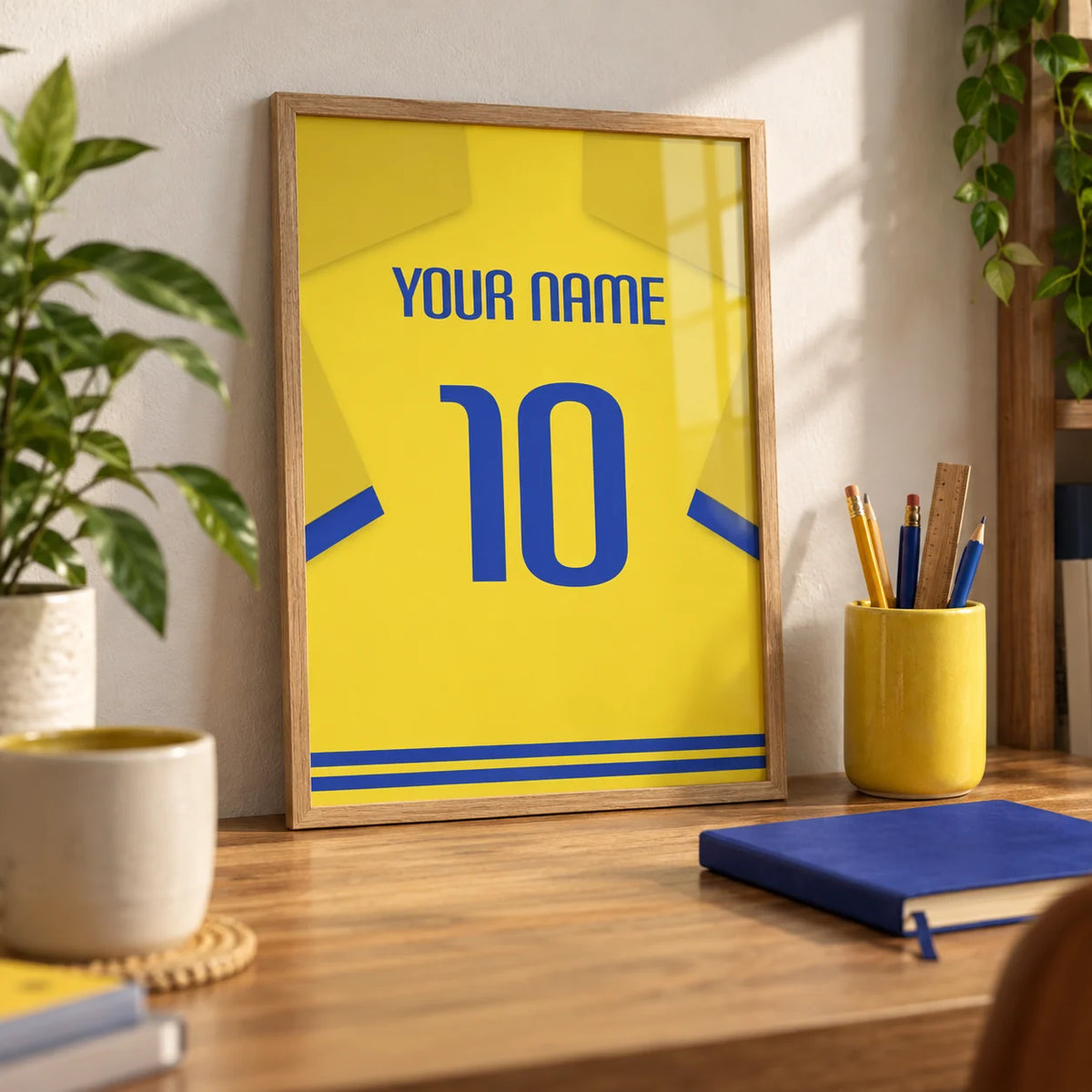 Football Shirt Poster in Yellow with Blue Trim, a small A4 framed print leaning on an oak desk