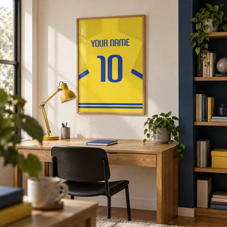 Football Shirt Poster in Yellow with Blue Trim, framed on the wall of a young adult football fan's home study (22-35) with a warm white wall and a navy painted alcove