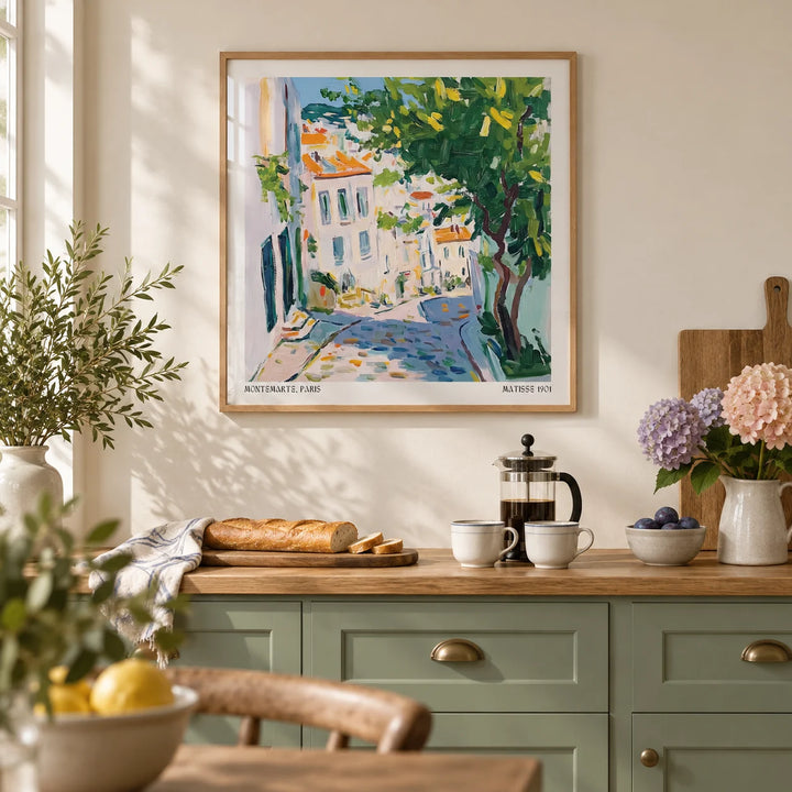 French Artwork Prints, framed on the wall of a French-inspired kitchen with a cream wall and plain sage green cabinets