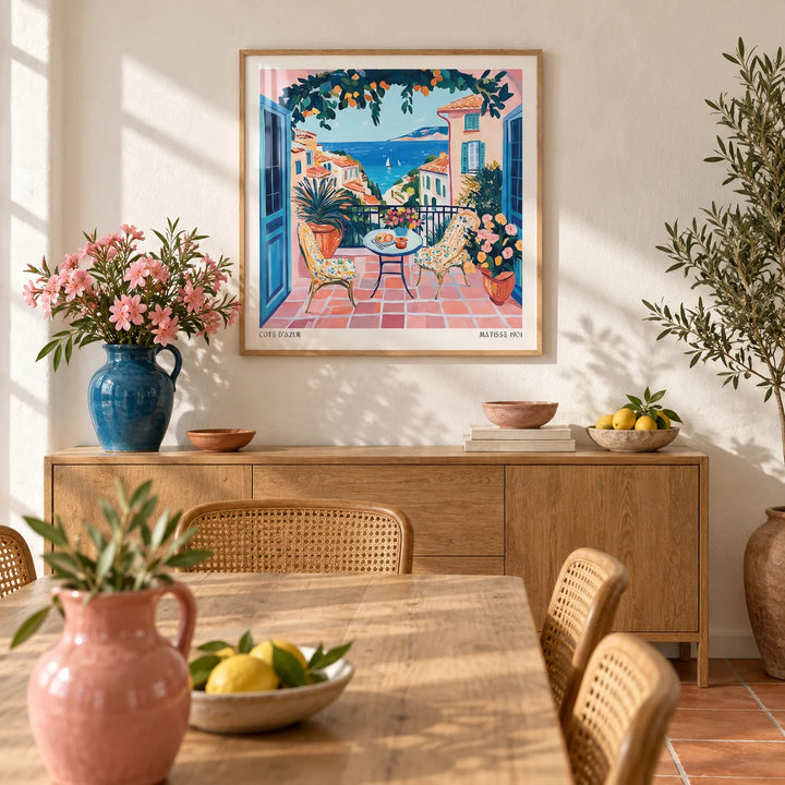 French Coastal Wall Art, framed on the wall of a sunny Mediterranean dining room with a warm white limewashed wall and a plain terracotta floor