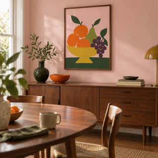 Fruit Bowl Print, framed on the wall of a mid-century dining room in a UK family home with pale pink walls and a walnut floor