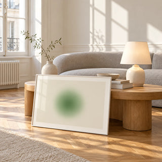 Green Aura Poster, framed and leaning against a coffee table in a bright living room