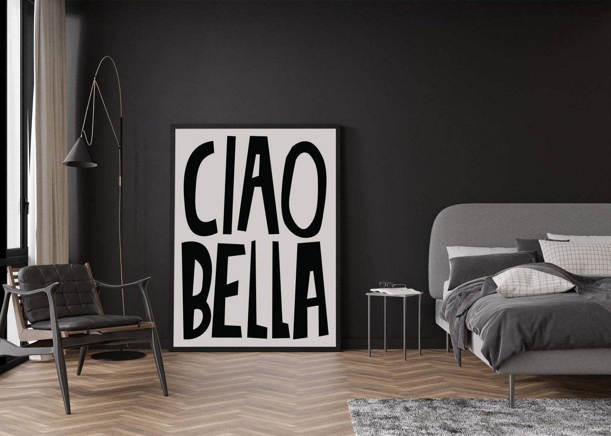 Black and White Typography Poster leaning against a dark wall near a grey bed and black chair in a bedroom
