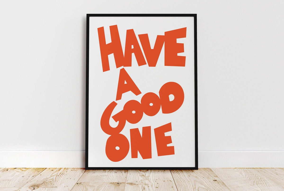 Wall Art Typography framed print with orange text on white leaning on wooden floor