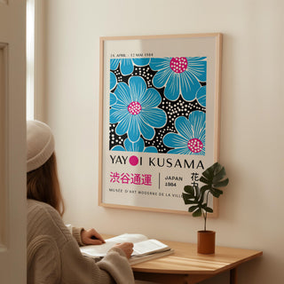 Large Modern Floral Wall Art with blue flowers and pink centres in a minimalist style above a wooden desk with plant