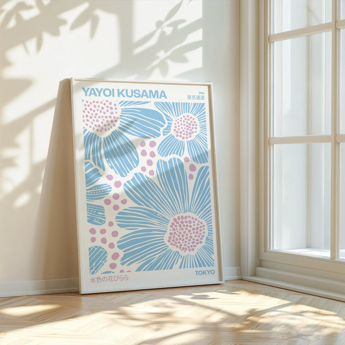 Print leaning on wooden floor by window with light blue and pink floral illustration