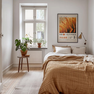 Autumnal wall art of wheat plants in orange and yellow tones above a beige bed in a bedroom