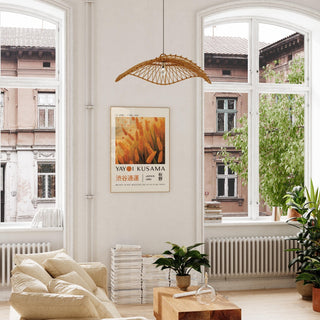 Autumnal wall art of golden wheat stalks in warm tones hanging in a bright room with plants on the floor