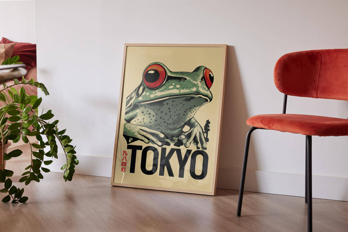 Frog poster leaning on floor with red-eyed frog illustration near green plant and red chair