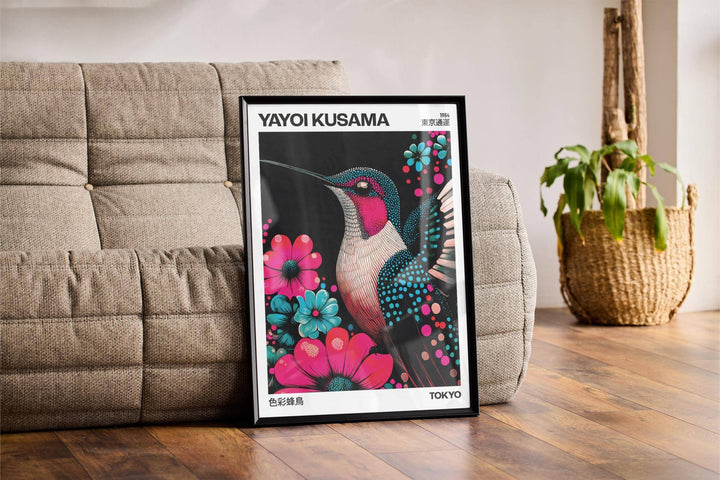 Framed Large Bird Prints leaning on a wooden floor beside a grey sofa and a woven plant basket