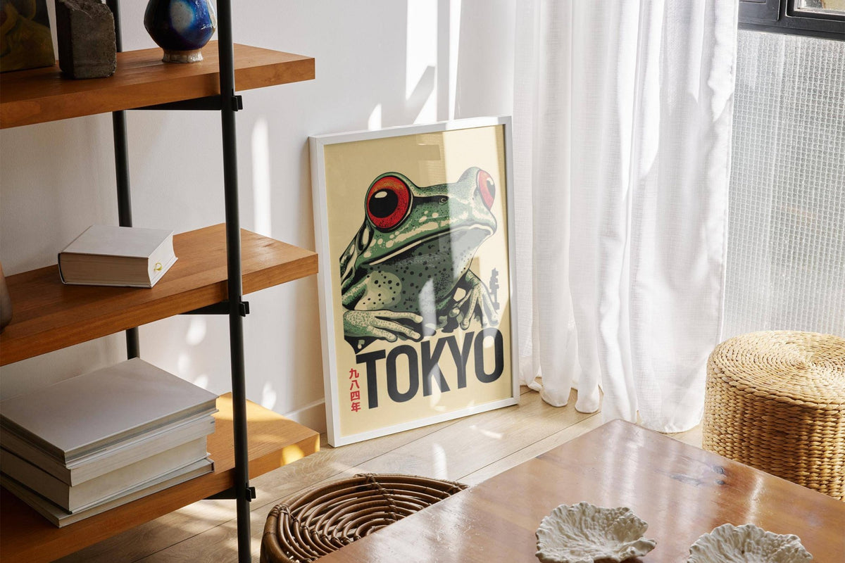 Frog poster leaning on a floor by a large window with light curtains and a wicker pouffe