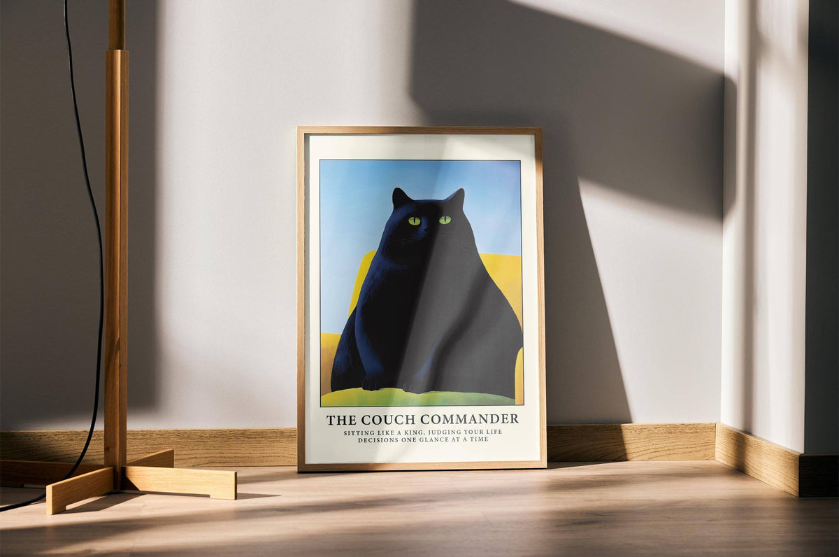 Framed Cat Funny Poster of a black cat on a yellow couch standing on a wooden floor next to a lamp