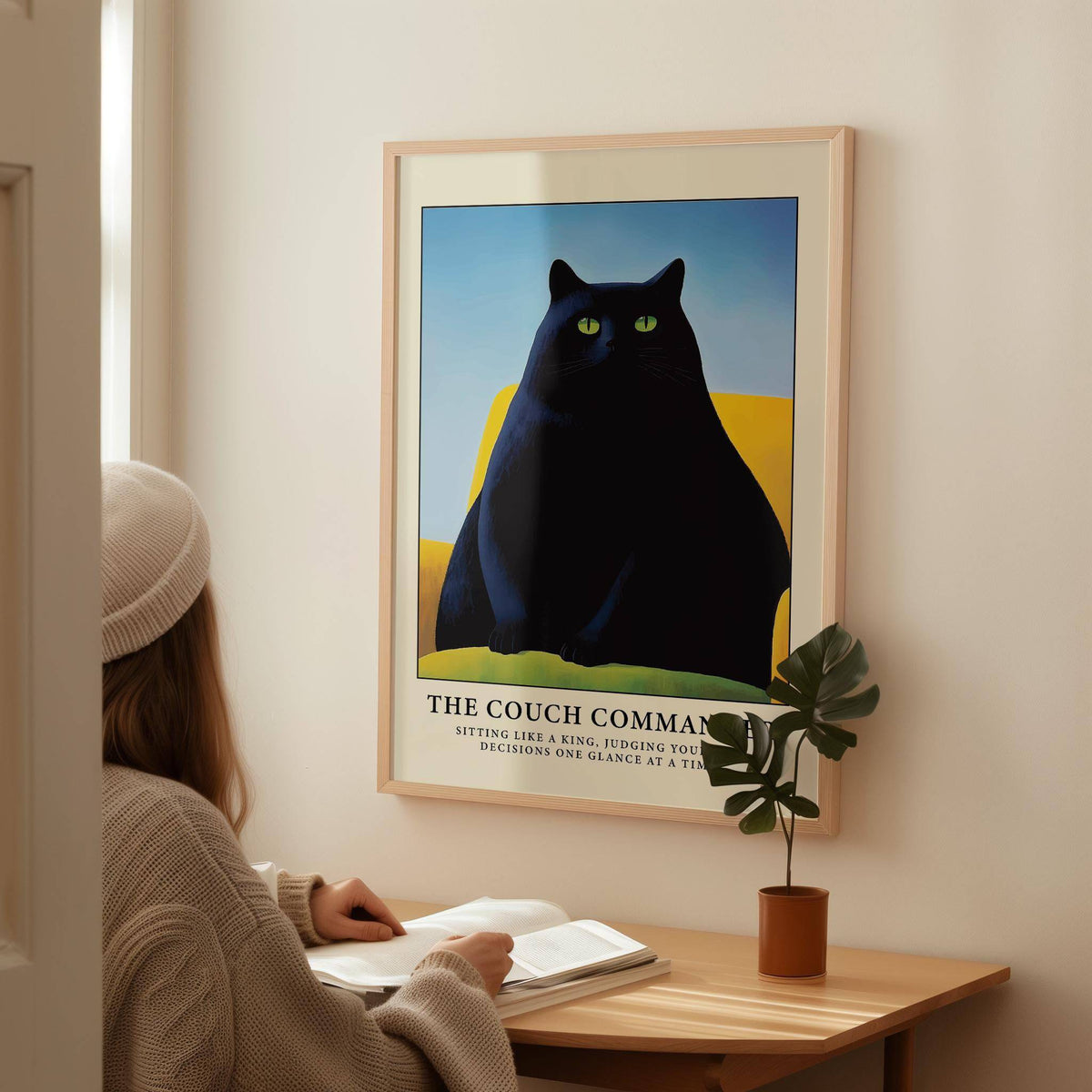 Cat Funny Poster framed print of a black cat on a yellow couch above a wooden desk with plant