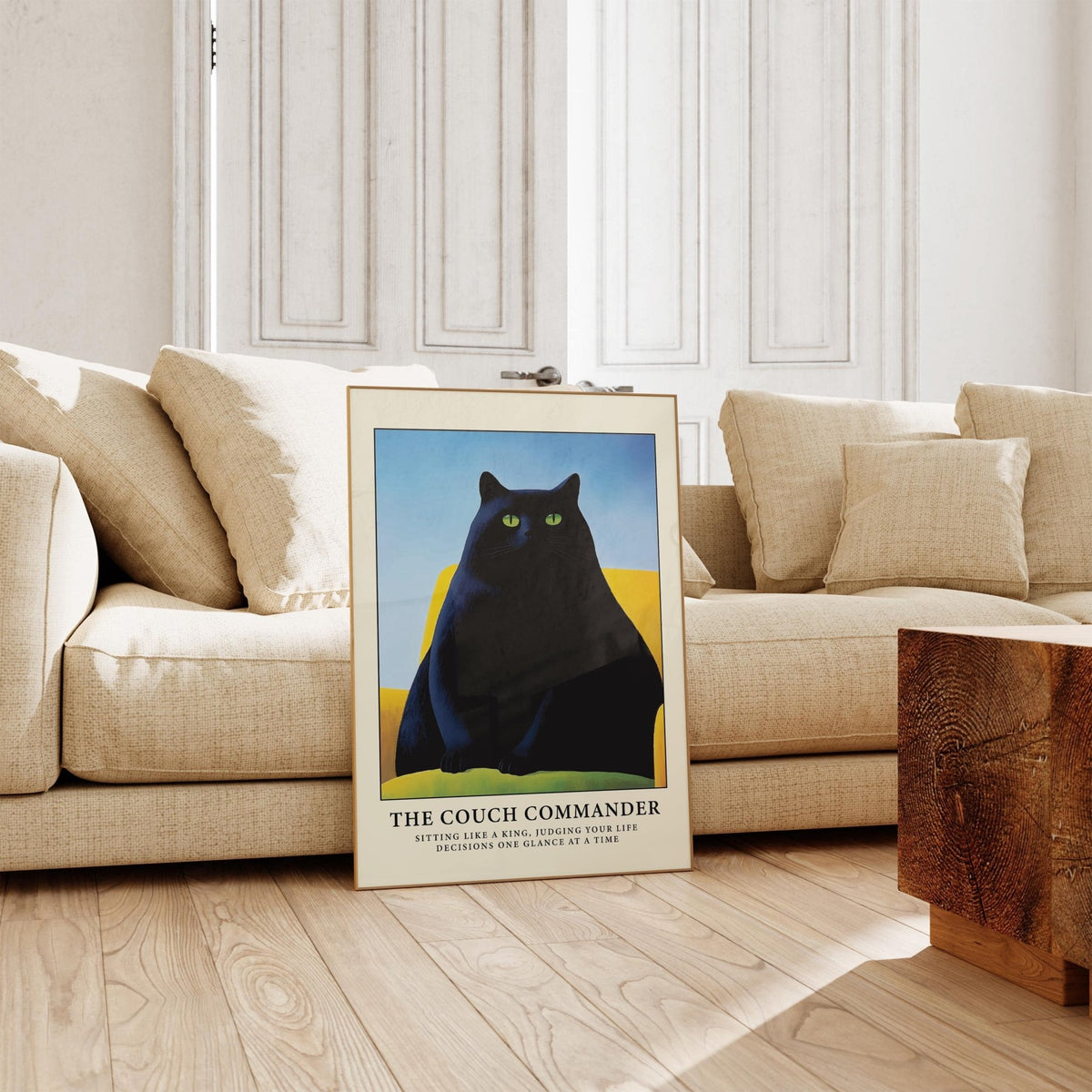 Cat Funny Poster print leaning on floor showing black cat with green eyes on yellow couch in a beige sitting room