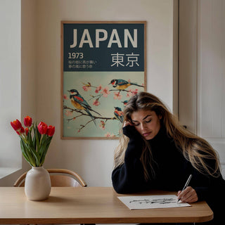 Japanese Bird wall art featuring swallows on a cherry blossom branch above a wooden table with tulips and a woman drawing