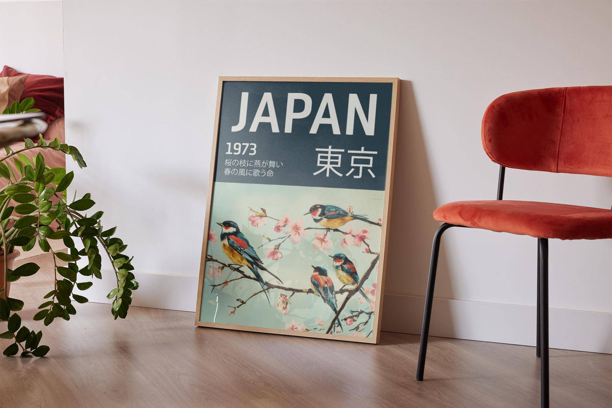 Japanese Bird wall art leaning on floor near red chair with green potted plant