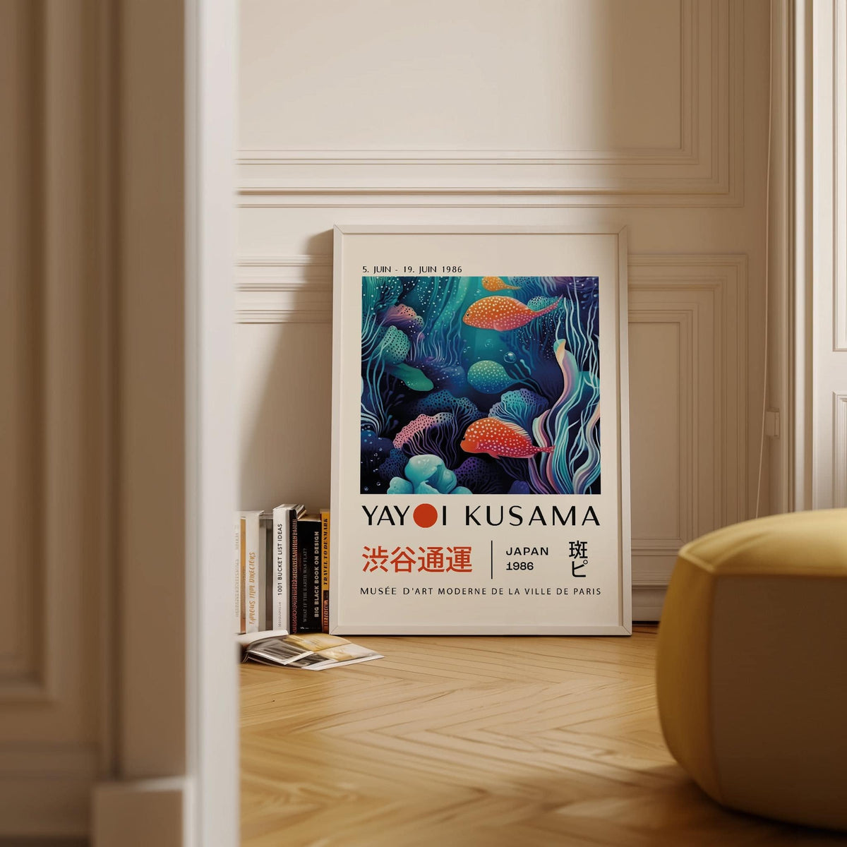 Colorful Fish Art print leaning on the floor next to a stack of books in a room