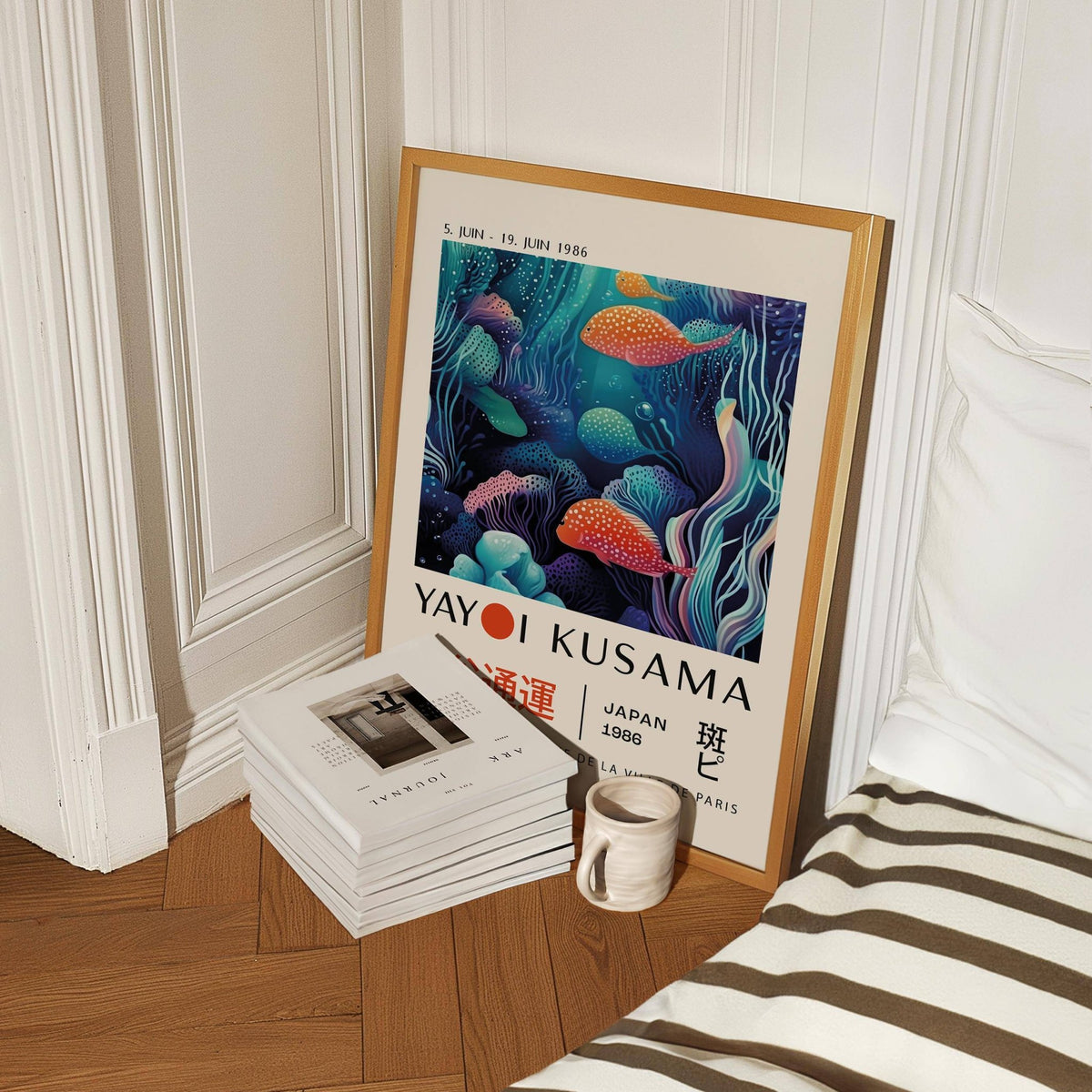 Colorful Fish Art print with spotted fish in blues and oranges leaning on a wooden floor near books and a mug