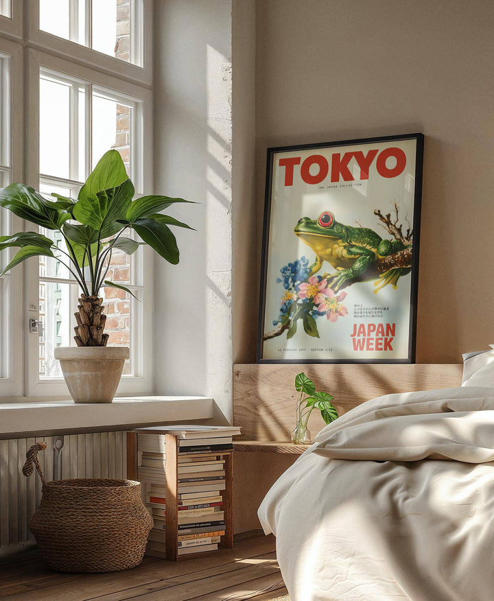Frog wall art showing a green frog on a branch with flowers leaning on a bedroom headboard with a glass bottle vase nearby