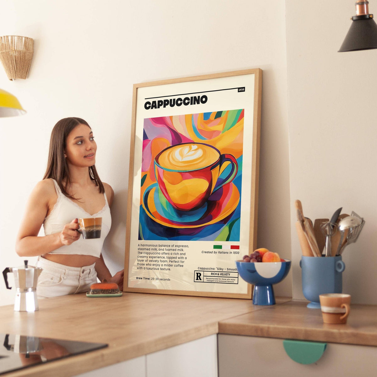 Coffee cup wall art pop art illustration in colourful tones leaning on kitchen worktop beside fruit bowl