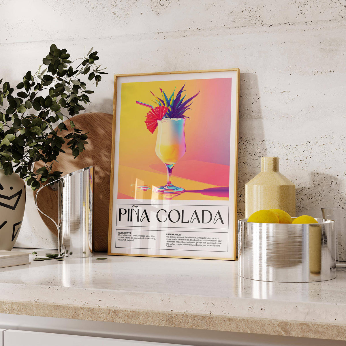 Drink wall art leaning on a kitchen worktop near a yellow ceramic vase and lemons